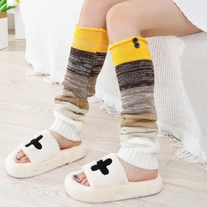 Jambières en tricot rayé pour femmes avec boutons et chaussons en peluche sur sol en bois