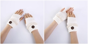 Close-up of white knit fingerless gloves with beige lace trim and a brown button detail