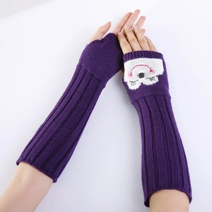 Detail van de gebreide textuur van paarse armwarmers met een wit smiley-gezichtpatroon