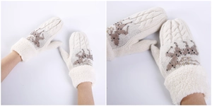 Dettaglio di muffole invernali in maglia con motivo a renna e bordo in ecopelliccia