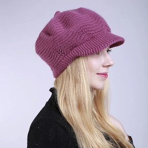 Detail view of purple knit peak cap with wave pattern on blonde female model