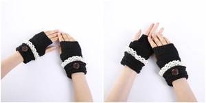 Detailed knit texture of black fingerless gloves with white lace and wood button