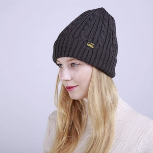 Detailed texture of dark grey cable knit beanie with premium woven brand label