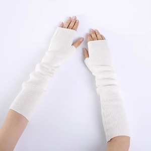 Detail of white knit fingerless gloves showing thick ribbed texture and thumb hole