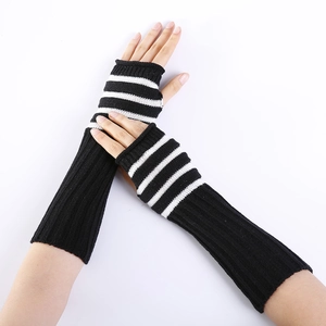 Detail of long knitted fingerless gloves with black and white stripes and thumb hole