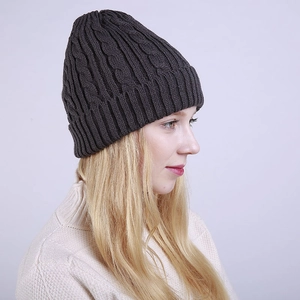 Detail showing the dark grey cable knit pattern and folded cuff of the winter beanie