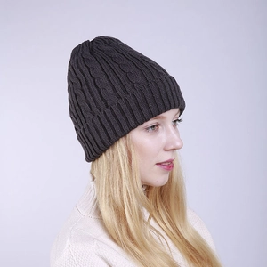 Detail of dark grey cable knit beanie with ribbed cuff on a model for winter warmth