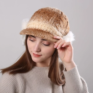 Detailed close-up of winter cable knit hat with visor and white faux fur ear muffs