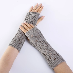 Close-up of light grey cable knit arm warmers with hollow diamond patterns and ribbed cuffs