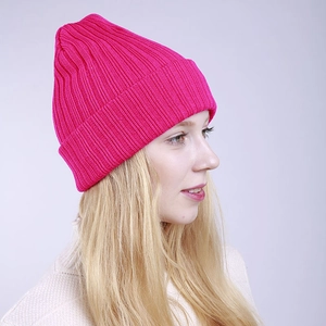 Side view of a bright rose pink ribbed knit beanie showing thick winter texture