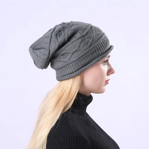 Detail of grey cable knit pattern and ribbed cuff on a winter slouchy beanie hat