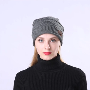 Detailed knit texture and leather logo patch on a grey winter beanie for skiing
