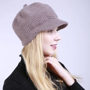 Detail of grey-pink knit peaked beret showing textured wave pattern on a female model