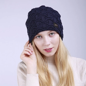 Detail der dunkelblauen Strickmütze mit Wellenstruktur und kleinem Leder-Zierlabel am Rand