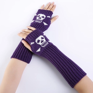 Macro detail of purple knitted fingerless long gloves featuring a white skull pattern