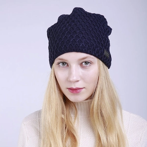 Detalle del gorro de punto azul marino con patrón de rombos en modelo rubia