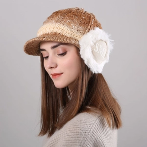 Close-up of knit winter hat with white faux fur earflaps and SMI embroidery detail