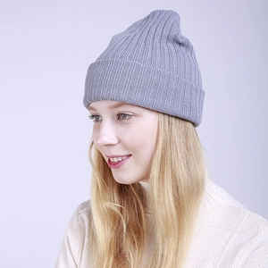 Detailed close-up of light grey ribbed knit texture on a folded winter beanie cap