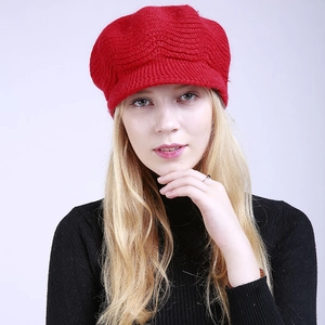Close-up of red knit beret with visor showing thick wool texture and warm winter design