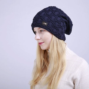 Detail der dunkelblauen Strickmütze mit 3D-Wellenmuster und Lederaufnäher-Akzent