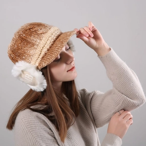 Detail of warm winter knitted hat with faux sherpa lining and letter B ear flap