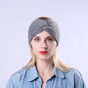 Détail d'un bandeau en tricot gris avec un nœud croisé et une texture côtelée