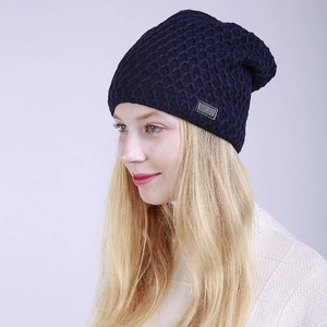 Primer plano de gorro de punto azul marino con textura de panal y parche de cuero
