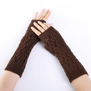Macro detail of dark brown cable-knit arm warmers with leaf hollow patterns