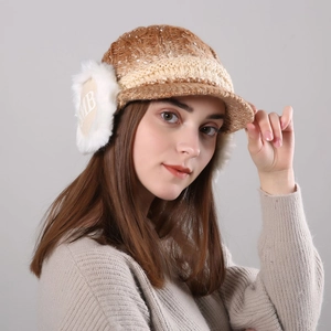 Detailed knit texture of a brown winter hat with soft faux fur ear flaps and brim