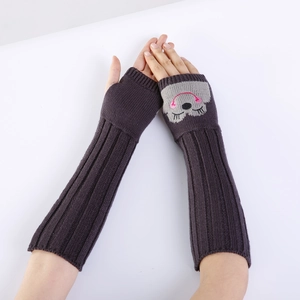 Detail van donkerbruine gebreide vingerloze armwarmers met geborduurd dierengezicht