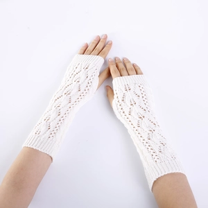 Detail of white knit fingerless gloves with hollow leaf pattern and ribbed cuffs