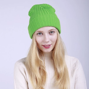 Close-up of bright neon green ribbed knit beanie with fold-over cuff design for winter