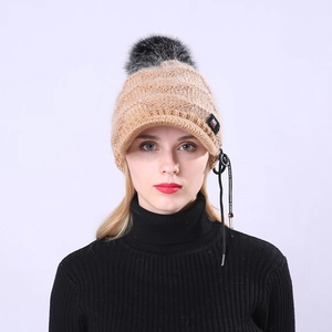 Detailansicht der khakifarbenen Strickmütze mit schwarzem Bommel und kurzem Schirm