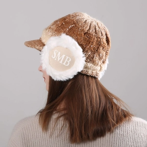 Detail of winter knit earflap cap with plush faux fur and SMB letter embroidery