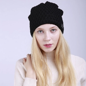 Detalle de gorro de punto negro con patrón de rombos y forro polar en modelo