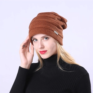 Detailansicht der braunen Strickmütze mit Wellenstruktur und modischem Etikett