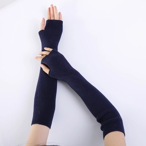 Detail of dark blue knit fingerless arm warmers showing ribbed texture and thumb hole