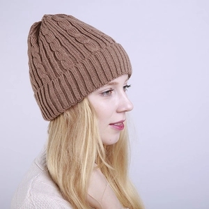 Detail of winter cable knit beanie featuring thick twist pattern and ribbed fold-over cuff