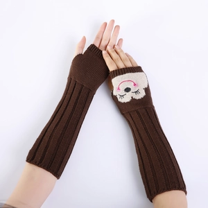 Detail van donkerbruine gebreide armwarmers met schattige witte wolkborduursels en ribstof