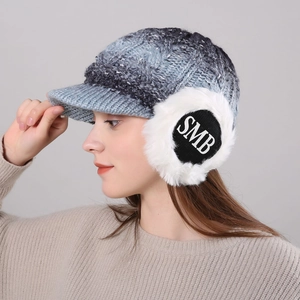 Detailed side view of gradient knit hat with ear flaps and white faux fur trim decoration