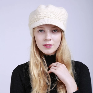 Detailed knit pattern on a cream winter visor beanie hat for women in close-up