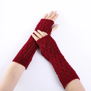 Detail of burgundy cable knit fingerless gloves with openwork leaf pattern and warm arm sleeves