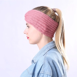 Gros plan sur un bandeau d'hiver rose tricoté avec un nœud croisé élégant porté