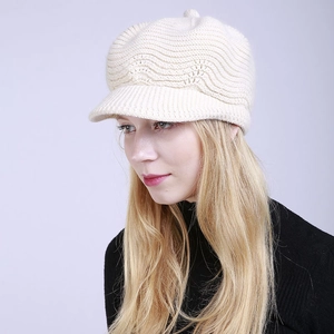 Detail of beige knitted newsboy cap featuring elegant 3D wave texture and ribbed brim