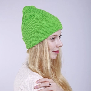 Close-up of bright green ribbed knit beanie showing textured vertical stripes and cuffed edge