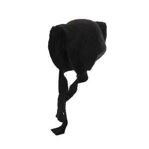 Detail of black chunky knit cat ear trapper hat with long ties and soft wool texture