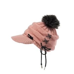 Detail der rosa Strickmütze mit schwarzem Pompon und KE SPORTS Markenriemen