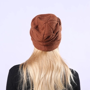 Rückansicht der braunen Strickmütze mit strukturierter Slouch-Passform am Modell