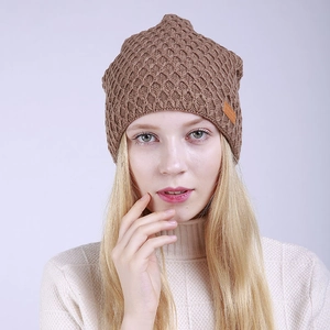 Detalle del gorro de punto marrón con textura de panal y parche de cuero decorativo