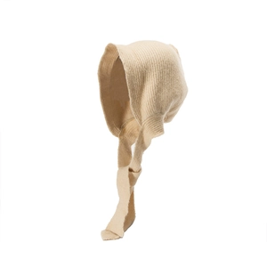 Detail of oat knitted bonnet with wide chin straps and soft ribbed texture for winter